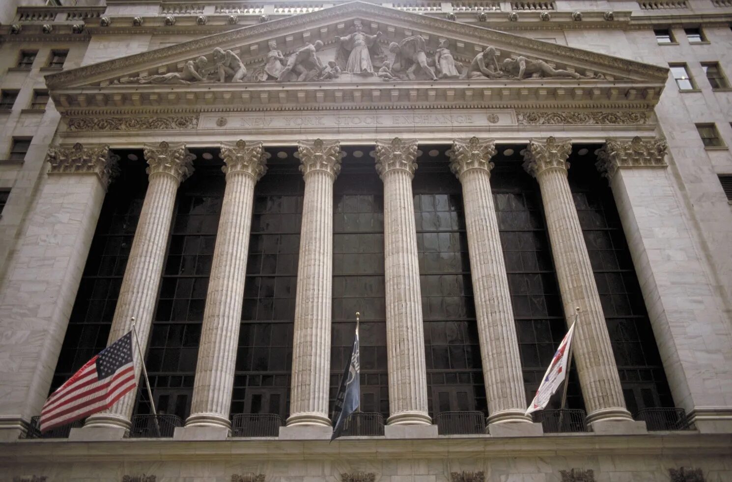 The New York Stock Exchange facade with columns and flags.
